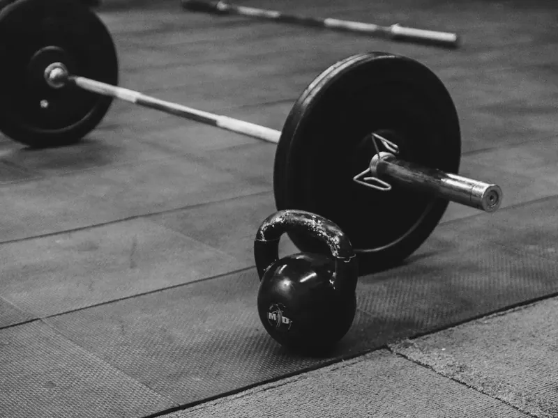 Loaded barbell on the platform at Forge Fitness, shot in high-contrast black and white